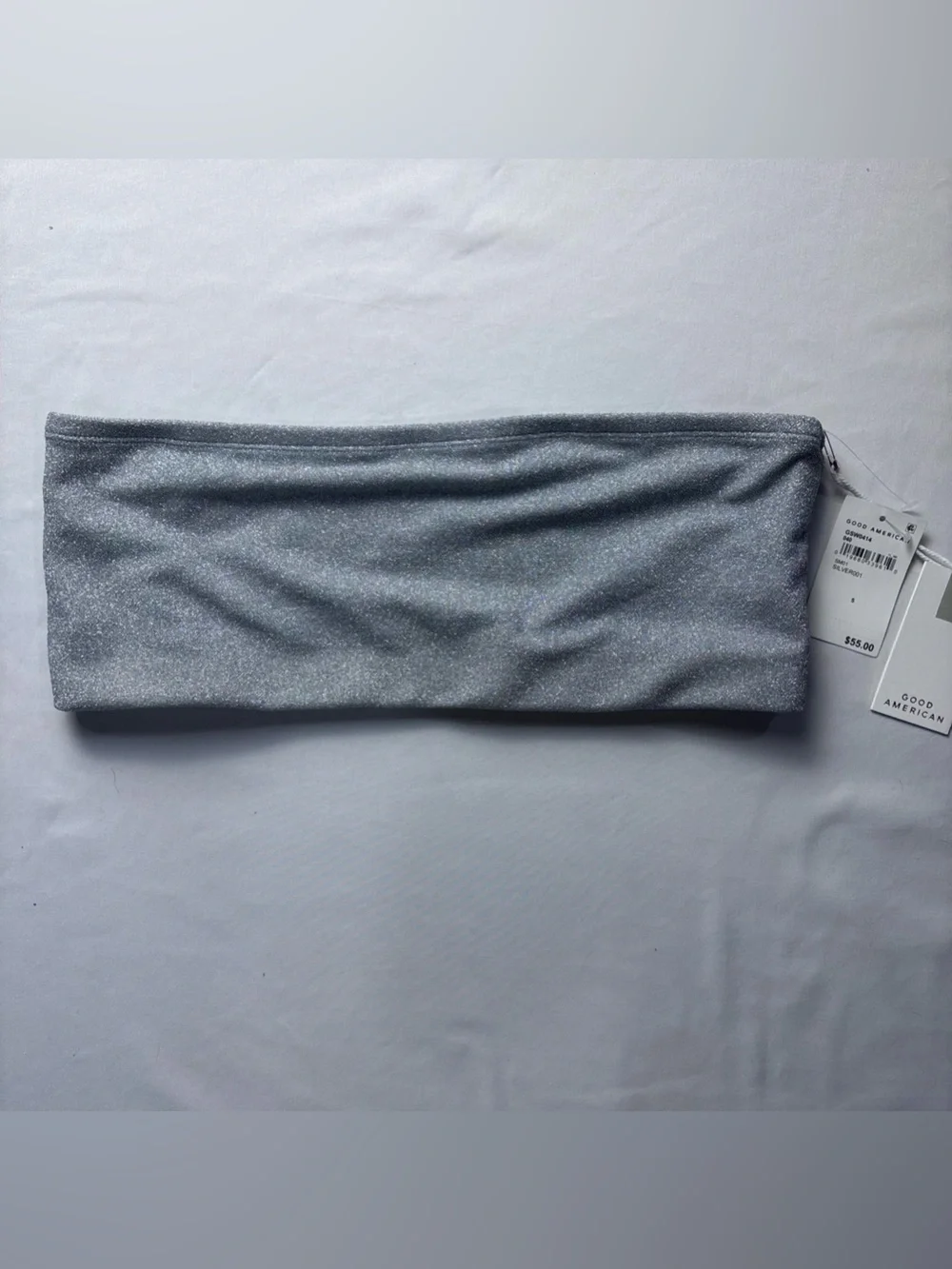 This Good American bandeau top features a shimmering silver fabric
